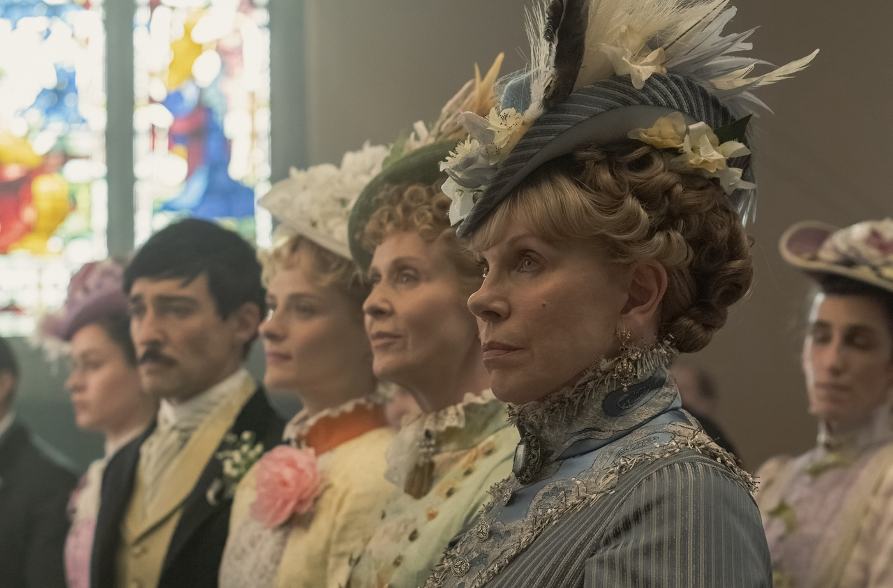 Une rangée de femmes et d'un homme vêtus de vêtements de la fin du XIXe siècle ;  encore de "L'âge d'or"