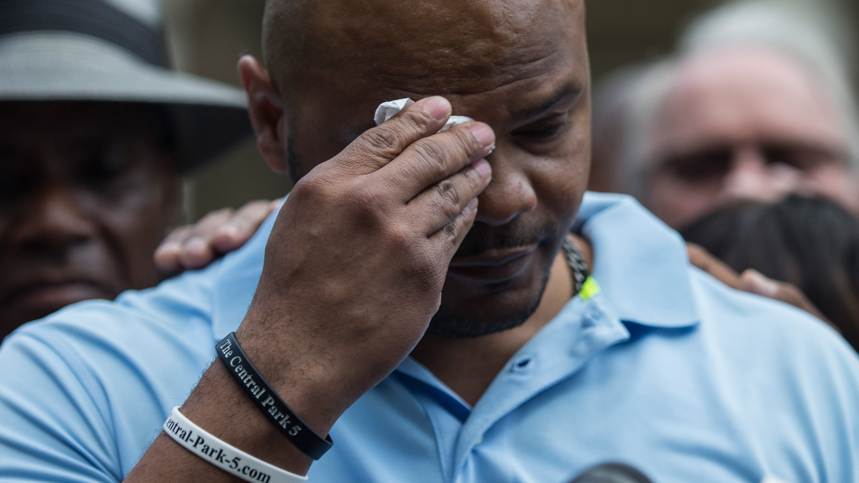 NEW YORK, NY - 27 JUIN : Kevin Richardson, l'un des cinq hommes condamnés à tort pour avoir violé une femme à Central Park en 1989, s'essuie le front alors qu'il s'exprime sur les marches de l'hôtel de ville lors d'une conférence de presse après qu'il a été annoncé que les hommes connu comme "Central Park Cinq," s'était réglé avec la ville de New York le 27 juin 2014 à New York pour environ 40 millions de dollars.  Les cinq hommes ont passé du temps en prison jusqu'à ce que leur condamnation soit annulée en 2002 après avoir prouvé leur innocence.  (Photo par Andrew Burton/Getty Images)