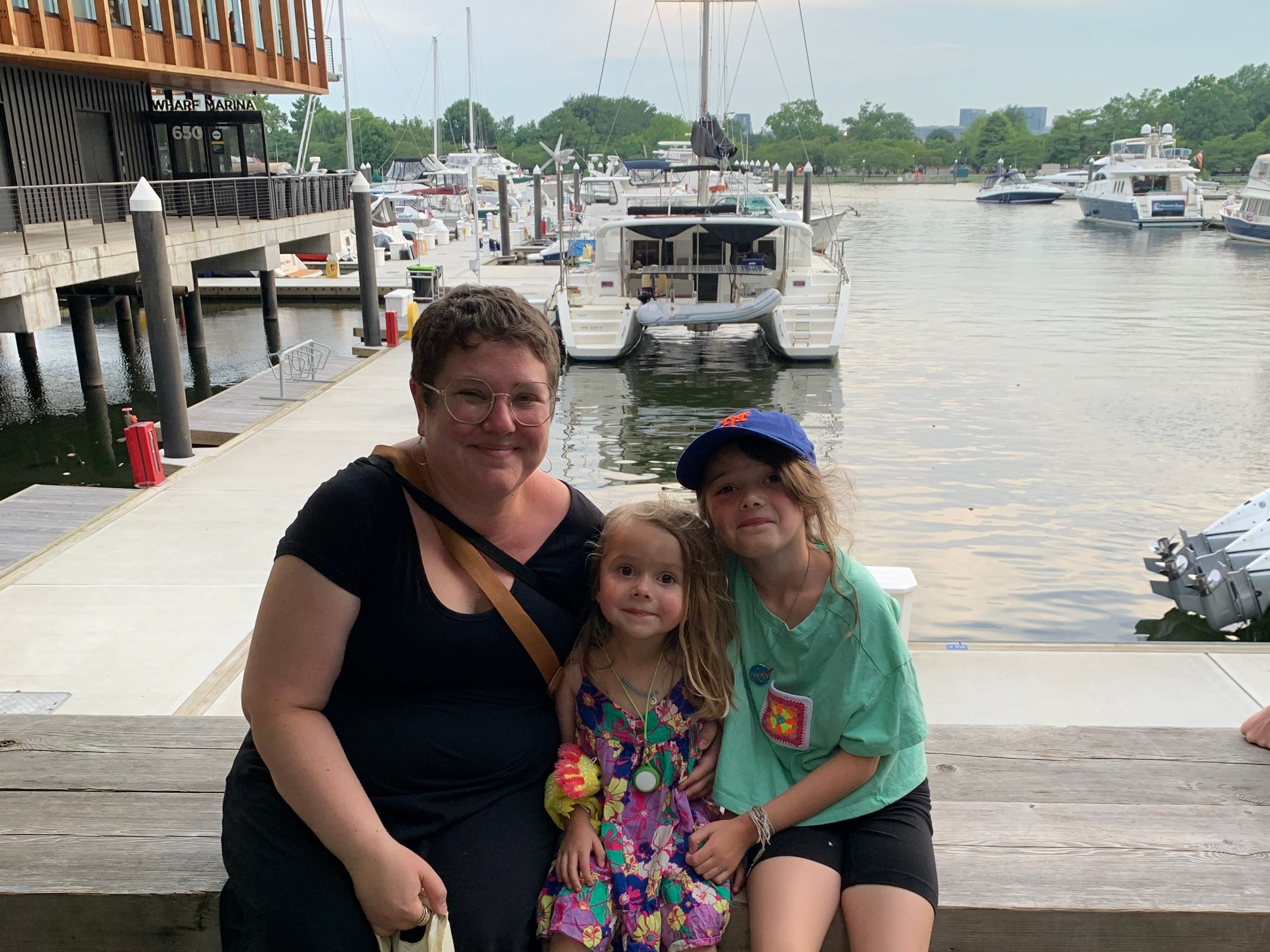 Lauren et ses enfants sont assis sur la jetée du Wharf District de DC