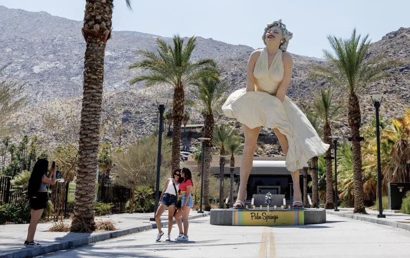 PALM SPRINGS, CA - 8 JUILLET 2024 : les touristes prennent des photos devant une statue de Marilyn Monroe alors que les températures montent jusqu'à 118 degrés le 8 juillet 2024 à Palm Springs, Californie. (Gina Ferazzi/Los Angeles Times)